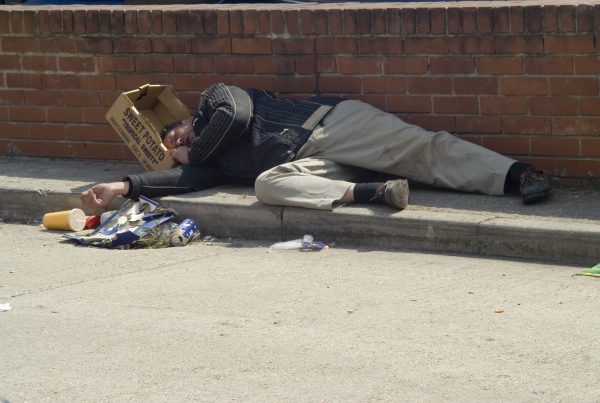 Man lying on street with sweet potato box